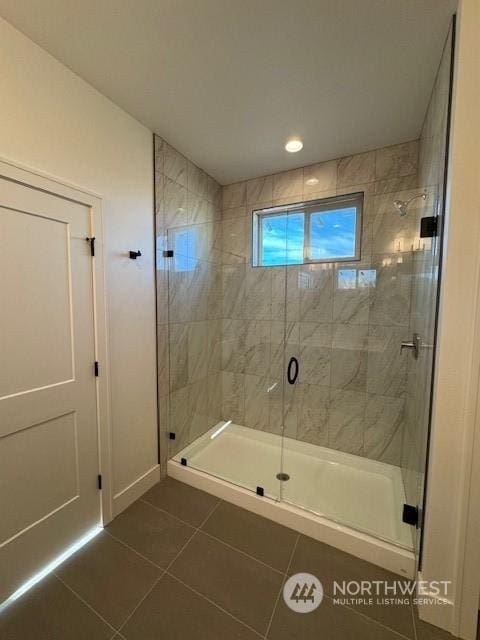 bathroom featuring tile patterned flooring and an enclosed shower