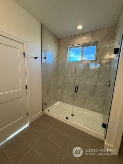 bathroom featuring a shower with door and tile patterned floors