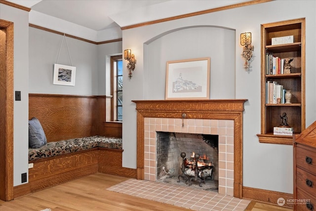 living room with a fireplace, wood-type flooring, and crown molding