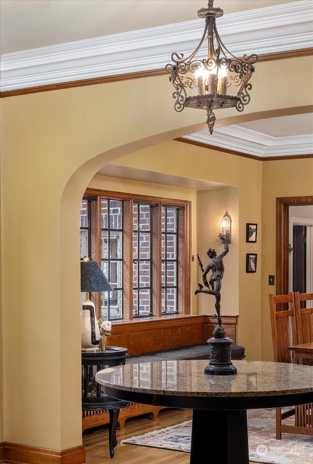 dining space featuring hardwood / wood-style floors, a chandelier, and ornamental molding