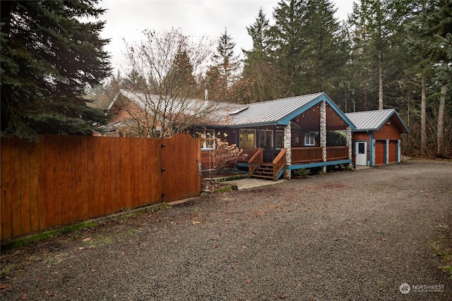 view of front facade featuring a deck, a garage, and an outdoor structure