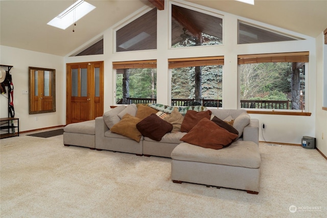 carpeted living room featuring beamed ceiling, a skylight, high vaulted ceiling, and a wealth of natural light