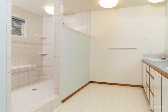 bathroom featuring a tile shower and vanity