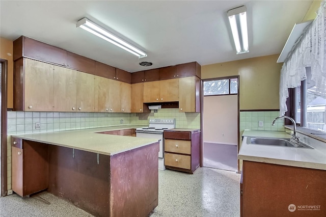 kitchen with white range with electric cooktop, kitchen peninsula, sink, and a wealth of natural light