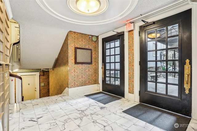 entryway with a textured ceiling and a raised ceiling