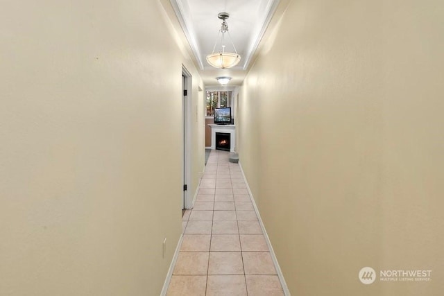 hall featuring crown molding and light tile patterned flooring