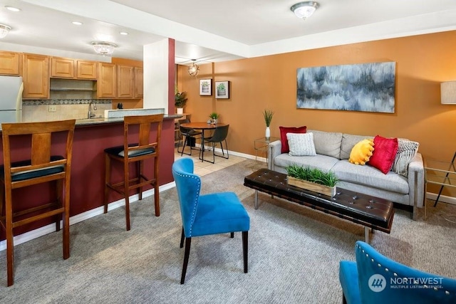 carpeted living room with sink