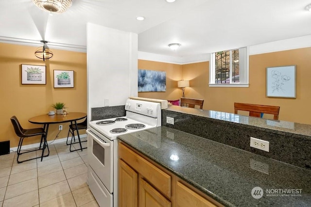 kitchen with electric range, pendant lighting, light tile patterned flooring, and dark stone counters