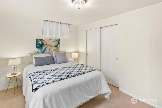 bedroom featuring light colored carpet, crown molding, and a closet