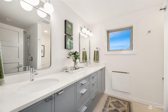 bathroom with tile patterned flooring, vanity, and tiled shower