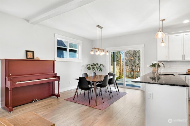 dining area featuring a chandelier, sink, and light hardwood / wood-style flooring