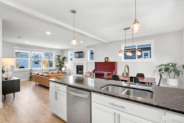 kitchen featuring decorative light fixtures, stainless steel dishwasher, white cabinetry, and sink