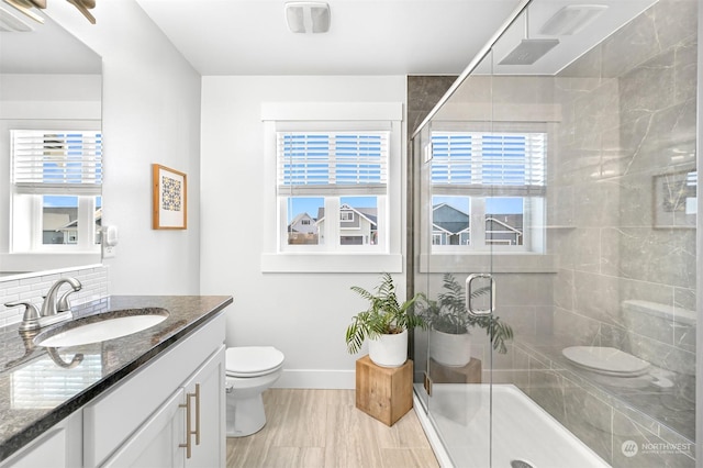 bathroom featuring decorative backsplash, toilet, vanity, and walk in shower