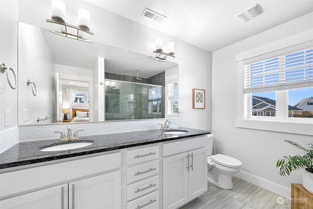 bathroom with hardwood / wood-style flooring, vanity, toilet, and walk in shower