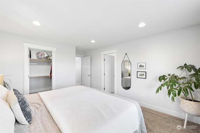 carpeted bedroom featuring a walk in closet and a closet