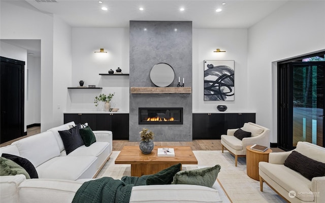 living room with a large fireplace and light hardwood / wood-style flooring