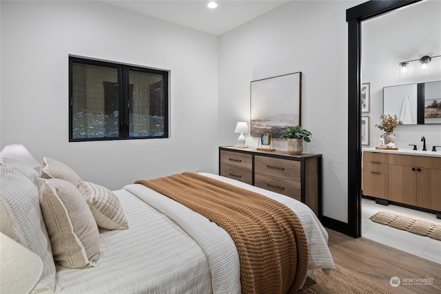 bedroom featuring light wood-type flooring and sink