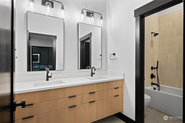 full bathroom featuring vanity, tiled shower / bath combo, and toilet