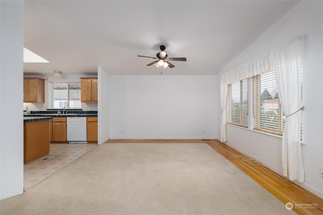 interior space featuring ceiling fan, sink, vaulted ceiling, and light wood-type flooring