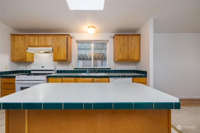 kitchen featuring a kitchen island, white appliances, and sink