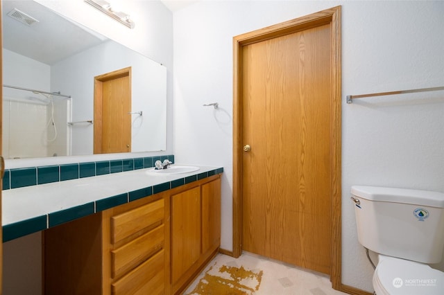 bathroom with vanity, tasteful backsplash, toilet, and walk in shower