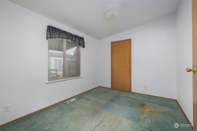 carpeted empty room with vaulted ceiling