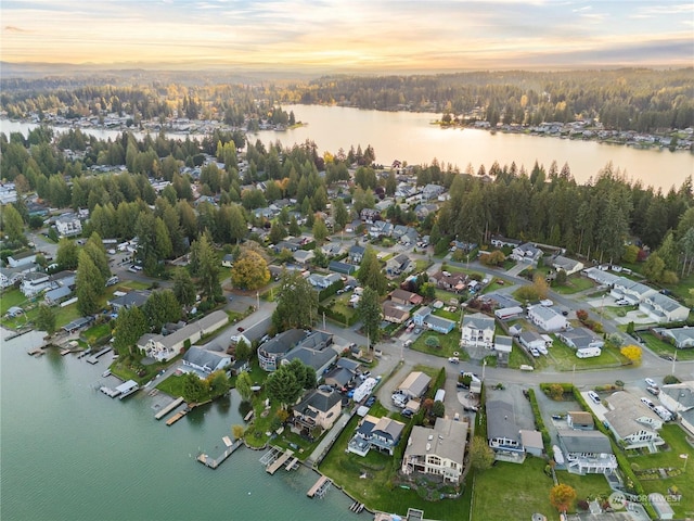 aerial view at dusk featuring a water view