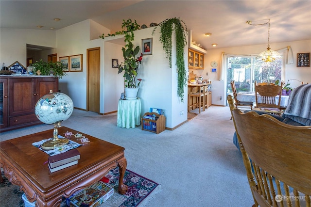 carpeted living room featuring a chandelier and lofted ceiling