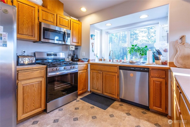 kitchen with light tile patterned flooring, stainless steel appliances, and sink