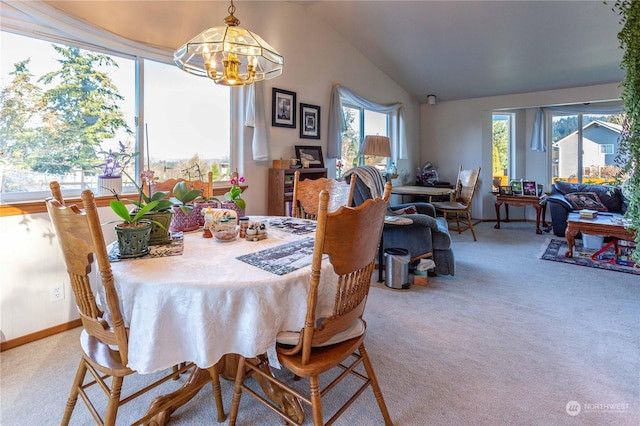 dining area featuring carpet flooring, a chandelier, a healthy amount of sunlight, and vaulted ceiling