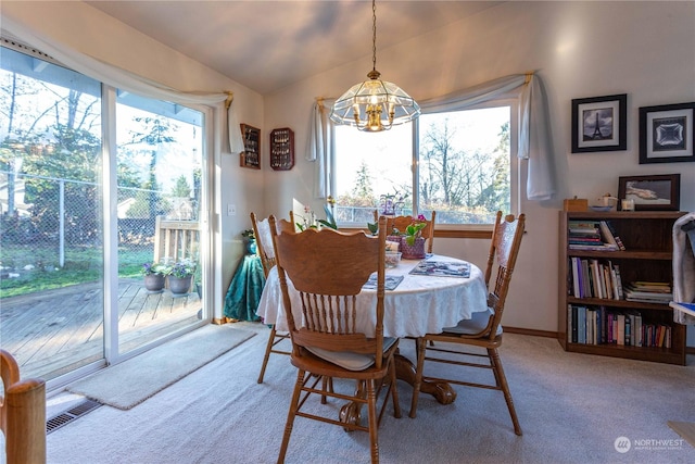 dining area with carpet flooring and an inviting chandelier