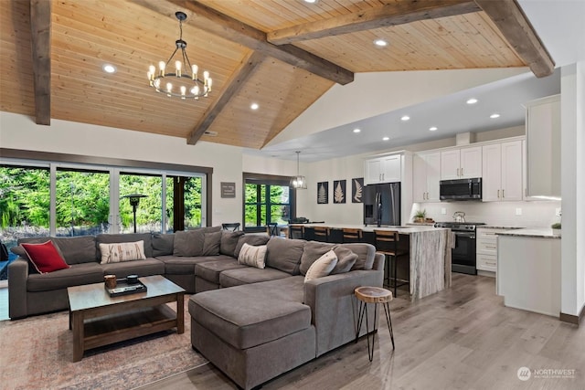 living room featuring beam ceiling, high vaulted ceiling, an inviting chandelier, light hardwood / wood-style flooring, and wooden ceiling