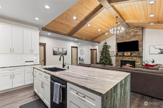 kitchen with dishwasher, sink, lofted ceiling with beams, a center island with sink, and white cabinets