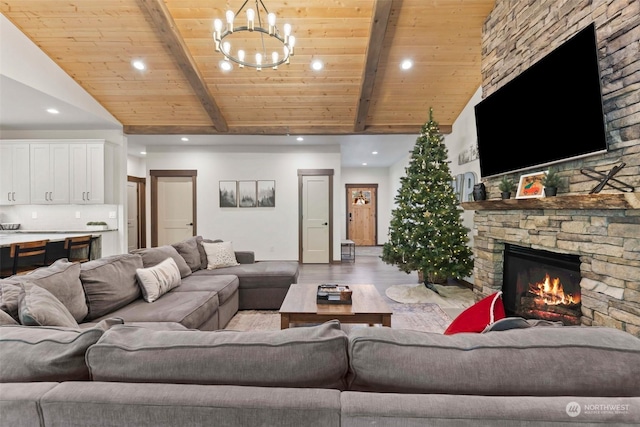 living room featuring wooden ceiling, a stone fireplace, light wood-type flooring, beam ceiling, and a chandelier