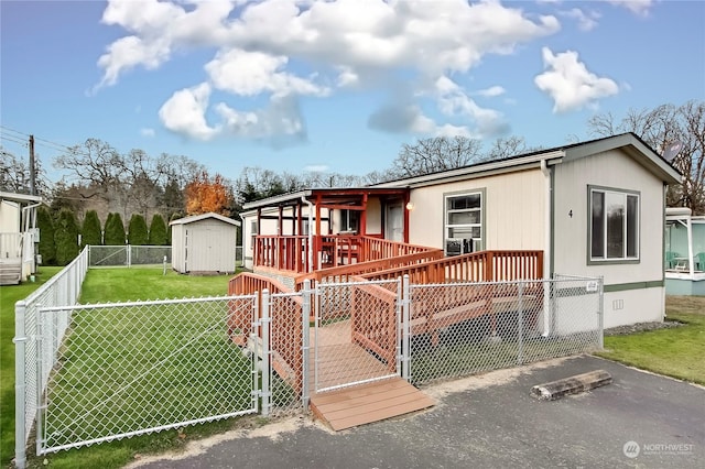 manufactured / mobile home with a front yard and a shed