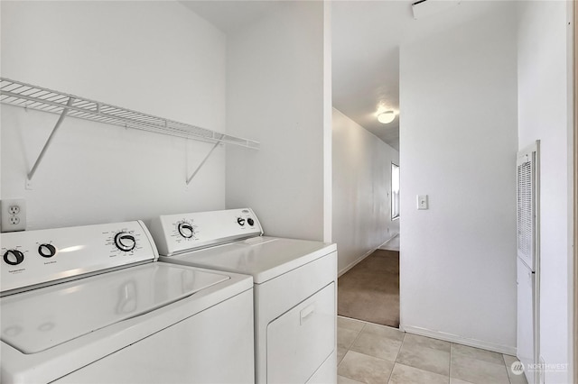 laundry room featuring washing machine and dryer and light tile patterned floors