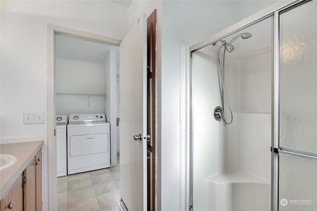 bathroom with tile patterned floors, vanity, an enclosed shower, and separate washer and dryer