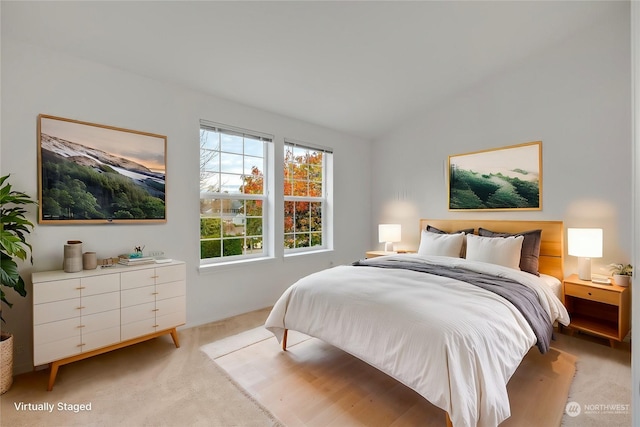 bedroom featuring lofted ceiling and light colored carpet