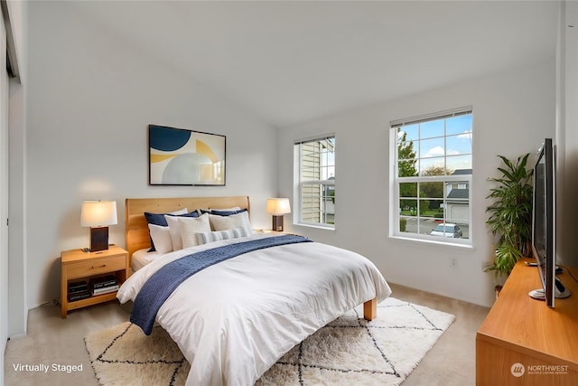 carpeted bedroom with lofted ceiling