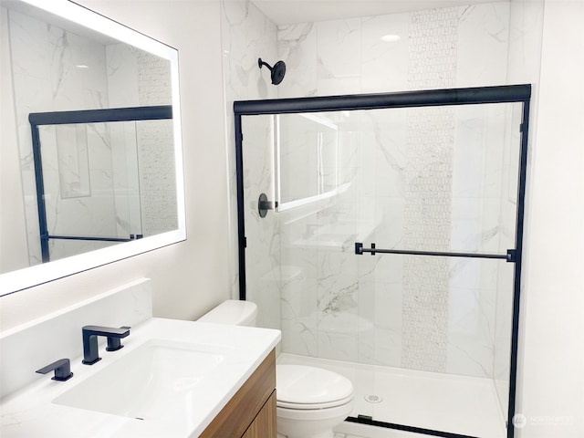 full bathroom featuring a stall shower, vanity, and toilet