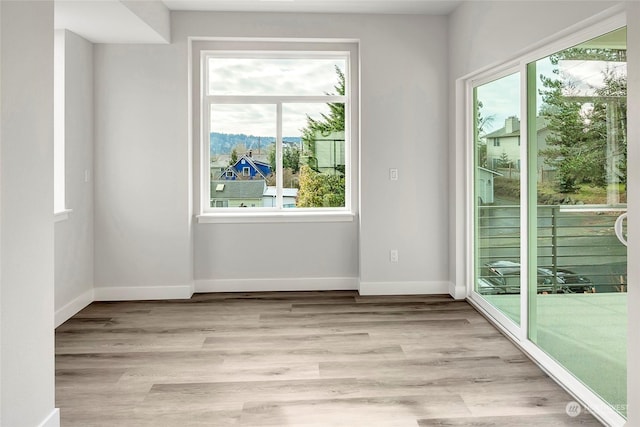 empty room with light wood-style flooring and baseboards