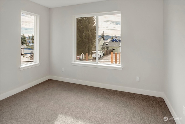 unfurnished room featuring carpet flooring and baseboards