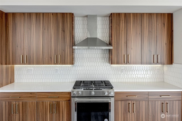 kitchen featuring tasteful backsplash, wall chimney range hood, and high end stainless steel range