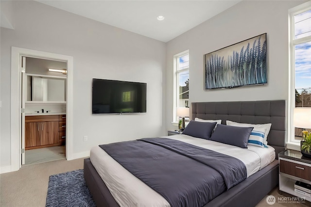 bedroom featuring recessed lighting, ensuite bathroom, carpet flooring, a sink, and baseboards