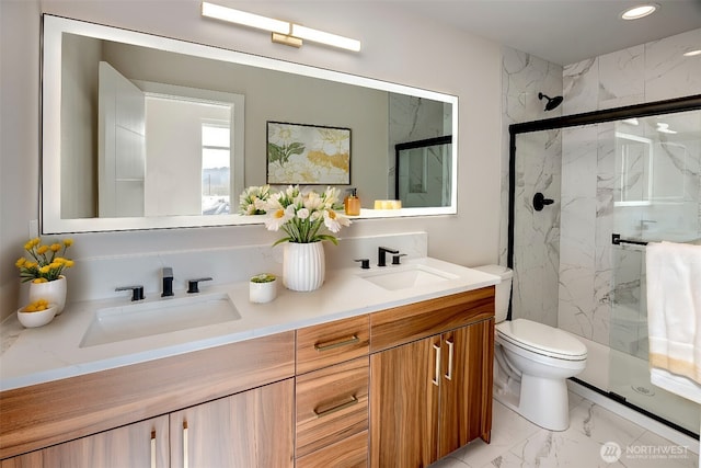 full bath with toilet, marble finish floor, a sink, and a marble finish shower