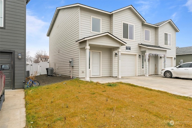 view of front of house featuring a front lawn, a garage, and cooling unit