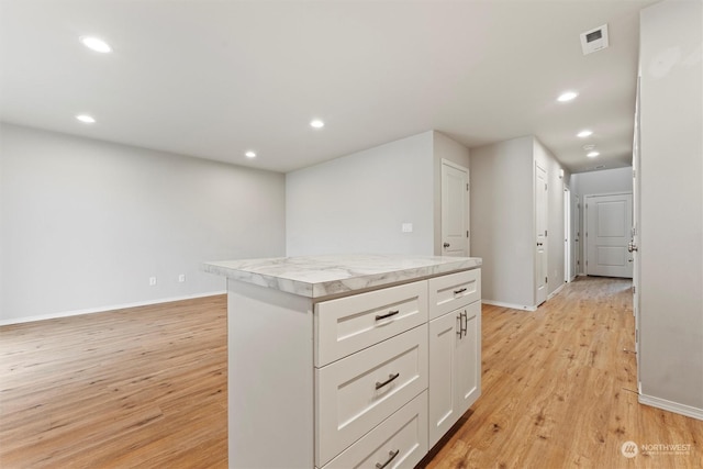 kitchen featuring white cabinetry, light hardwood / wood-style flooring, and a kitchen island