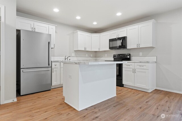 kitchen with a center island, light hardwood / wood-style flooring, white cabinets, and black appliances