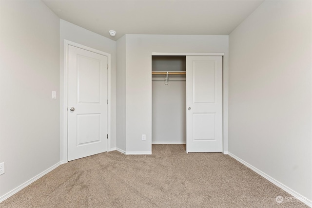 unfurnished bedroom featuring a closet and carpet floors