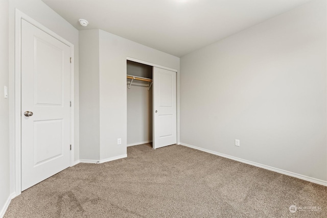 unfurnished bedroom featuring carpet flooring and a closet